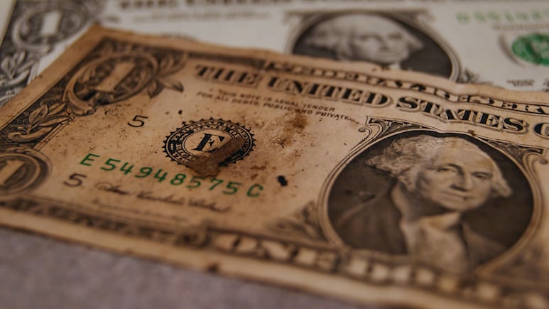 Billete de dólar sucio y destruído.